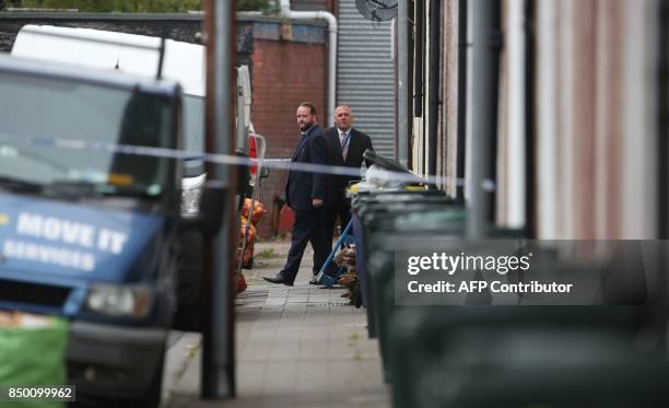 Police officers work inside a police cordon near to a house in Newport, south Wales, on September 20 as they continue their investigations into the...