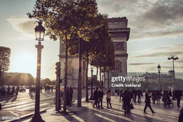 triumphal arch of the star against sunset - champs elysees quarter stock pictures, royalty-free photos & images