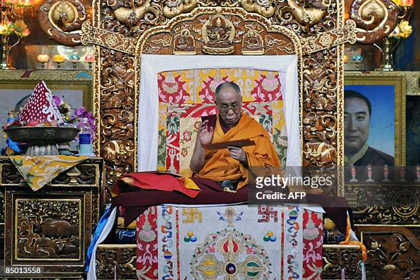 Tibetan spiritual leader The Dalai Lama reads from Buddhist scripture during a prayer session on the eve of Tibetan New Year at the Bylakuppe Tibetan...