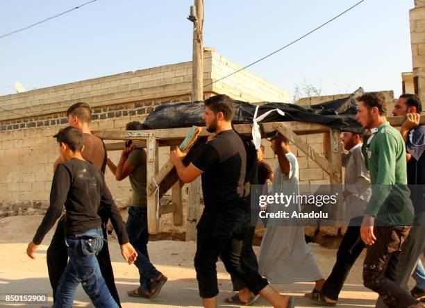 People carry the dead body of a civilian after Abu Bakr As-Siddiq Mosque was hit with an air strike in Idlib, Syria on September 20, 2017. It is...