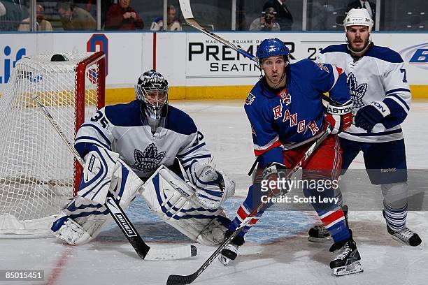 Ryan Callahan of the New York Rangers positions himself against goaltender Vesa Toskala and Ian White of the Toronto Maple Leafs on February 22, 2009...