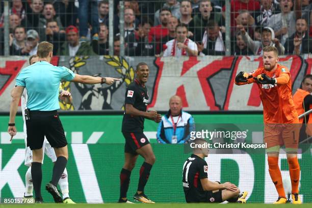 Referee Martin Petersen points to the penalty spot after goalkeeper Timo Horn of Koeln fouled Mijat Gacinovic of Frankfurt during the Bundesliga...