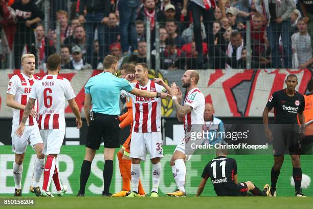 Referee Martin Petersen points to the penalty spot after goalkeeper Timo Horn of Koeln fouled Mijat Gacinovic of Frankfurt during the Bundesliga...