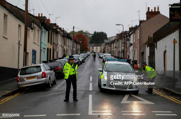 Police officers stand guard at a police cordon near to a house in Newport, south Wales, on September 20 as they continue their investigations into...