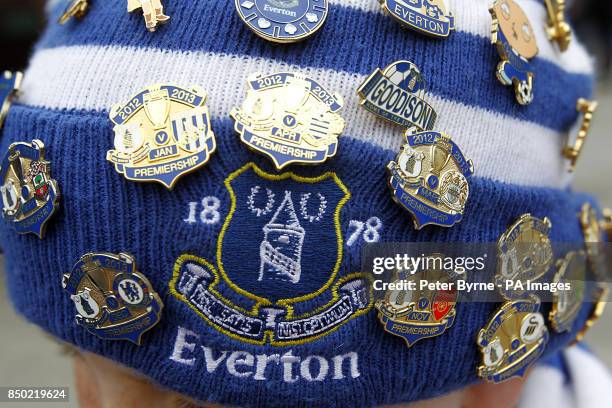 An Everton fan proudly shows off his collection of enamel badges