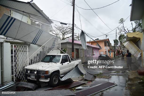Residents of San Juan, Puerto Rico, deal with damages to their homes on September 20 as Hurricane Maria batters the island. Maria slammed into Puerto...