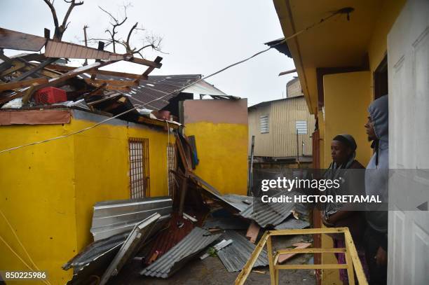 Residents of San Juan, Puerto Rico, deal with damages to their homes on September 20 as Hurricane Maria batters the island. Maria slammed into Puerto...