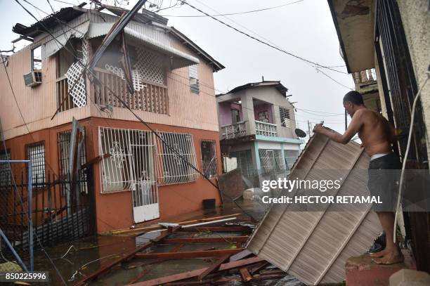 Residents of San Juan, Puerto Rico, deal with damages to their homes on September 20 as Hurricane Maria batters the island. Maria slammed into Puerto...