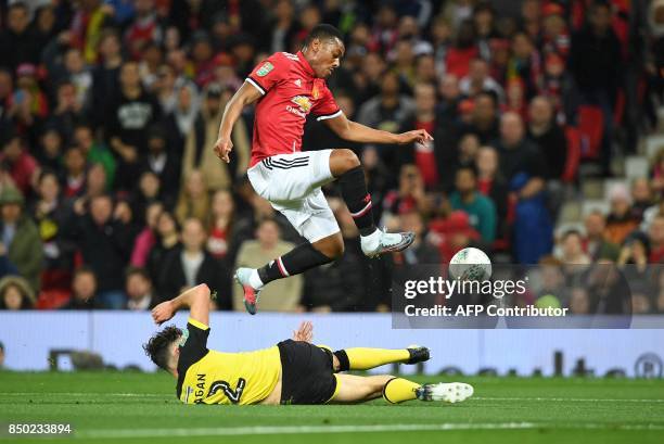 Manchester United's French striker Anthony Martial vies with Burton Albion's English-born Northern Irish defender Tom Flanagan during the English...