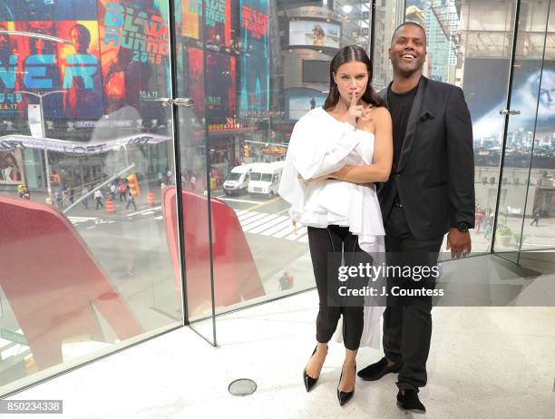 Model Adriana Lima poses for a photo with A. J. Calloway during her visit to 'Extra' at their New York Studios at H&M Times Square on September 20,...