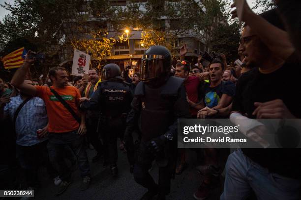 Demonstrators clash with Spanish National Police officers as they leave the road outside the Catalan Pro-Independence Lefty party CUP headquarters on...