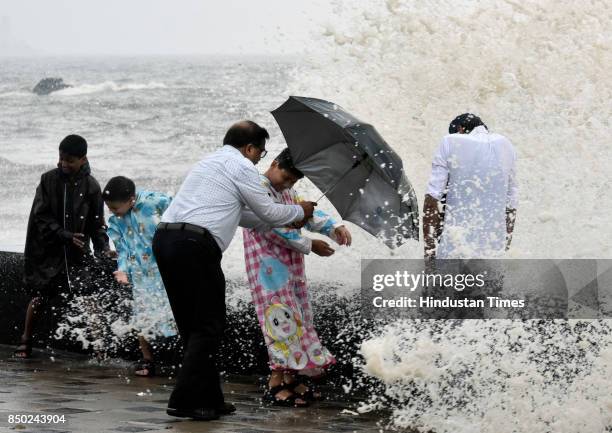 People enjoy during the high tide at Worli Seaface on September 20, 2017 in Mumbai, India. Torrential rain battered Mumbai and its suburbs for the...