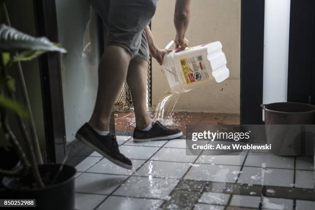 Resident dumps buckets of water out of a flooded home in the Miramar neighborhood afterHurricane Maria made landfall on September 20, 2017 in San...