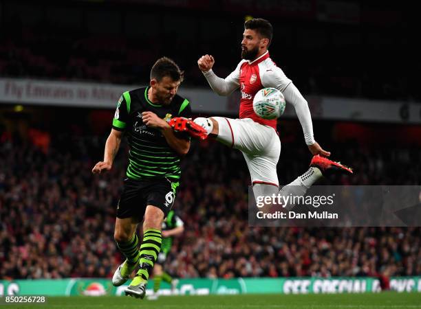 Olivier Giroud of Arsenal and Andy Butler of Doncaster Rovers battle for possession during the Carabao Cup Third Round match between Arsenal and...