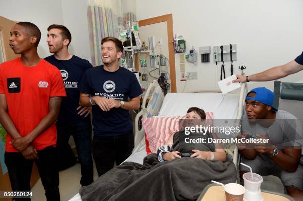 New England Revolution London Woodbury, Matt Turner, Kelyn Rowe, watch as teammate Claude Dielna battles Tobin at video games at Boston Children's...