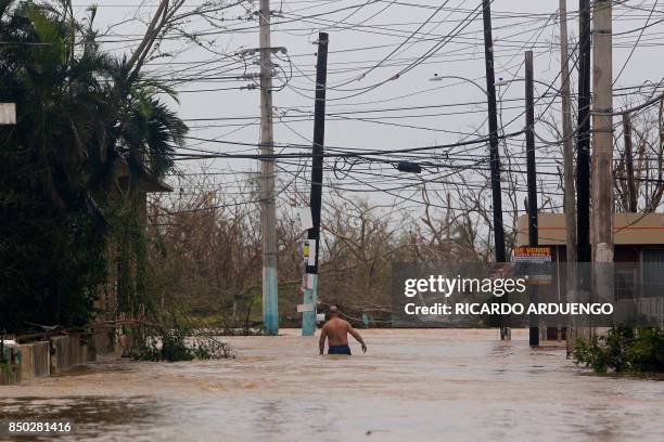 Man wades through a flooded road as Hurricane Maria hits Puerto Rico in Fajardo, on September 20, 2017. Maria made landfall on Puerto Rico, pummeling...
