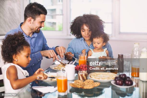 photo of a young happy family having breakfast - young family in kitchen stock pictures, royalty-free photos & images