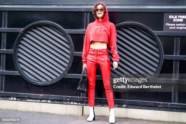 Model wears a red hoodie, red pants, white shoes, sunglasses, outside Roland Mouret, during London Fashion Week September 2017 on September 17, 2017...