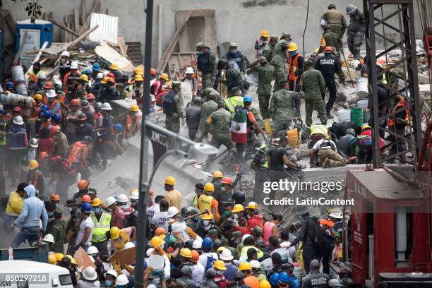 Rescuers and residents remove the rubble of a collapsed building a day after the magnitude 7.1 earthquake jolted central Mexico killing more than 200...