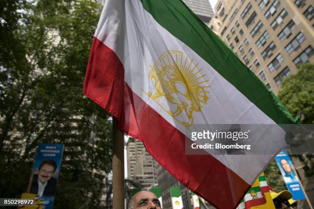 Demonstrator hold up an Iranian flag during a protest against Hassan Rouhani, Iran's president, not pictured, outside the UN General Assembly meeting...