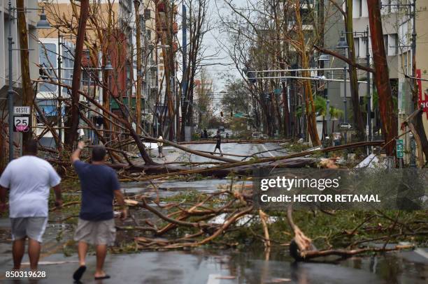 Men walk damaged trees after the passage of Hurricane Maria, in San Juan, Puerto Rico, on September 20, 2017. Maria slammed into Puerto Rico on,...
