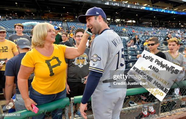 Neil Walker of the Milwaukee Brewers talks to a fan on a cell phone before the start of the game against the Pittsburgh Pirates at PNC Park on...