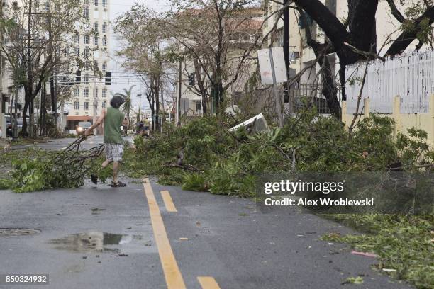 Resident cleans brush from the street in the Miramar neighborhood after Hurricane Maria made landfall on September 20, 2017 in San Juan, Puerto Rico....