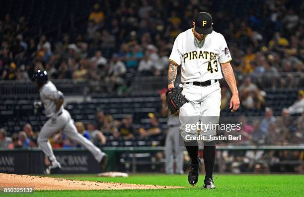 Steven Brault of the Pittsburgh Pirates reacts as Domingo Santana of the Milwaukee Brewers rounds the bases after hitting a solo home run in the...