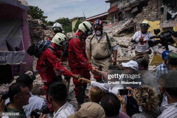 Enrique Pena Nieto, Mexico's president, center, shakes hands with rescue workers during a tour to survey the damage from a 7.1 magnitude earthquake...