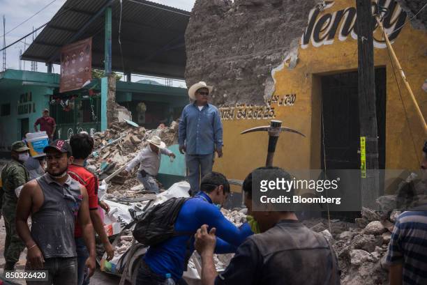People remove debris from a collapsed building of a business in the town of Jojutla de Juarez, Morelos State, Mexico, on Wednesday, Sept. 20, 2017....