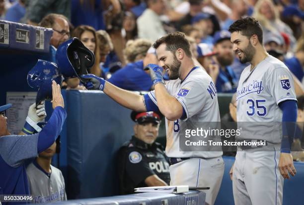 Mike Moustakas of the Kansas City Royals is congratulated by manager Ned Yost and Eric Hosmer after hitting a solo home run in the sixth inning,...