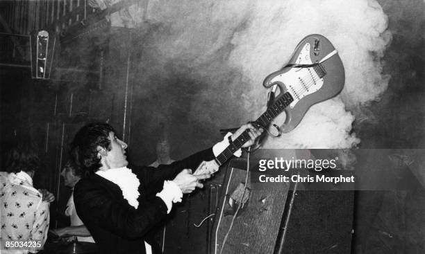 Photo of Pete TOWNSHEND and The Who, Pete Townshend performing live onstage, smashing guitar against amplifier