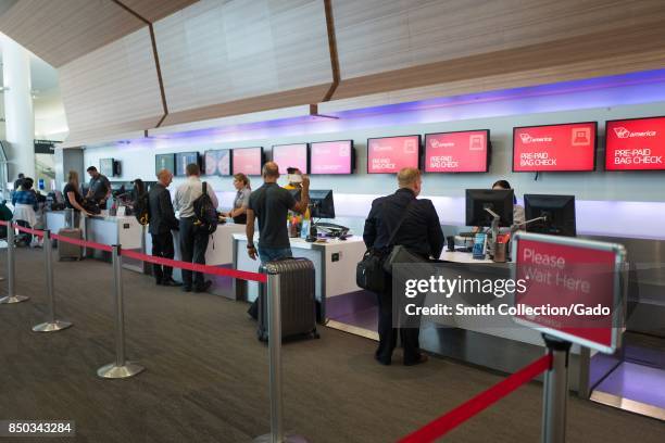 Travelers check in and drop off checked baggage at the Virgin America ticket counter at San Francisco International Airport , San Francisco,...