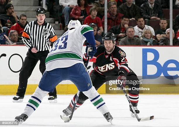 Jason Smith of the Ottawa Senators defends against Henrik Sedin of the Vancouver Canucks at Scotiabank Place on Feburary 19, 2009 in Ottawa, Ontario,...