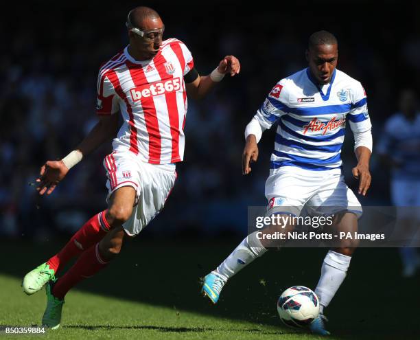 Queens Park Rangers' Junior Hoilett is challenge by Stoke City's Steven Nzonzi , during the Barclays Premier League match at Loftus Road, London.