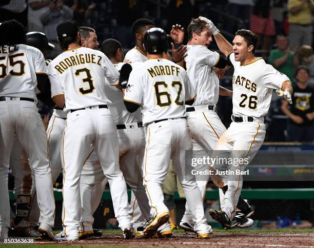 Adam Frazier of the Pittsburgh Pirates is greeted by teammates at home plate after hitting a walk off two run home run to right field in the ninth...