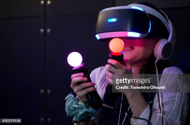 Visitor wearing a PlayStation VR headset plays a video game in the Sony Interactive Entertainment Inc. Booth during the Tokyo Game Show 2017 at...