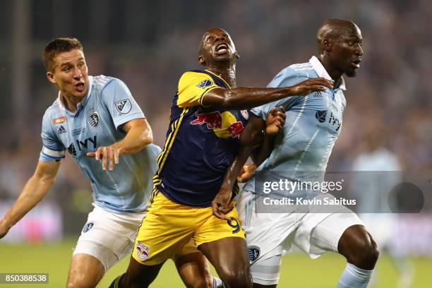 Bradley Wright-Phillips of the New York Red Bulls is hit by Matt Besler and Ike Opara of Sporting Kansas City in the US Open Cup Final match at...