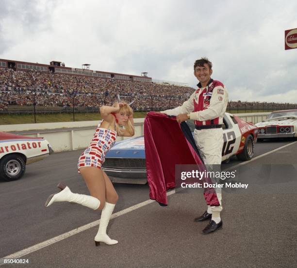 Driver Bobby Allison plays the Matador and Miss Winston, Bee Bop Hobel, plays the bull before the Coca-Cola 500 race on July 31, 1977 at the Pocono...