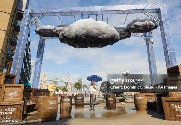 Former weather forecaster Michael Fish stands inside an interactive storm installation, which creates wind and rain, at a photocall at Shad Thames,...