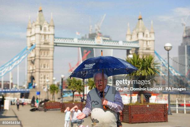 Former weather forecaster Michael Fish stands inside an interactive storm installation, which creates wind and rain, at a photocall at Shad Thames,...