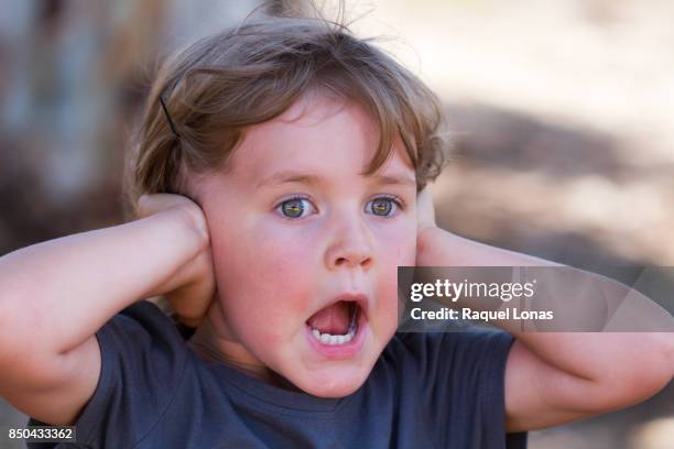 little girl covering her ears - hand to ear photos et images de collection