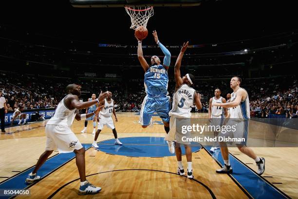 Carmelo Anthony of the Denver Nuggets goes to the basket against Dominic McGuire and Antawn Jamison of the Washington Wizards during the game on...