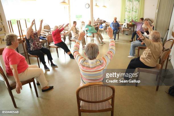 Elderly women lift their arms during an hour-long session of physical exercise at the Mireille Mathieu senior citizens' center on September 20, 2017...