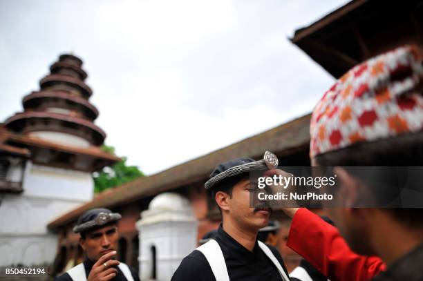 Nepalese Priest offering Red tika and holy flower to the member of Nepalese Army Personnel of Gurujuko Paltan after performing ritual puja during the...