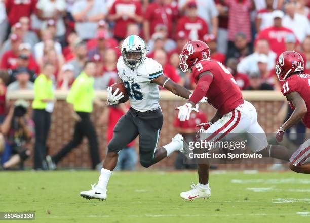 Tulane Green Wave Running Back Dontrell Hilliard runs away from OU defender Oklahoma Sooners LB Kenneth Murray during a college football game between...