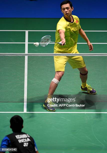 Hu Yun of Hong Kong hits a return against Srikanth Kidambi of India during their men's singles second round match at the Japan Open Badminton...