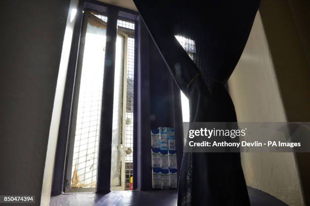 Drinks cartons are stored on a cell window inside Pentonville Prison, London.