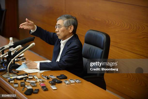 Haruhiko Kuroda, governor of the Bank of Japan , gestures as he takes questions while voice recorders sit on a bench during a news conference in...