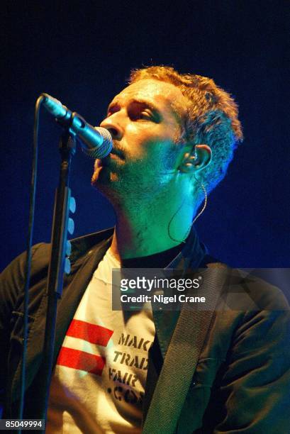 Photo of Chris MARTIN and COLDPLAY; Chris Martin performing live onstage, wearing make trade fair t-shirt